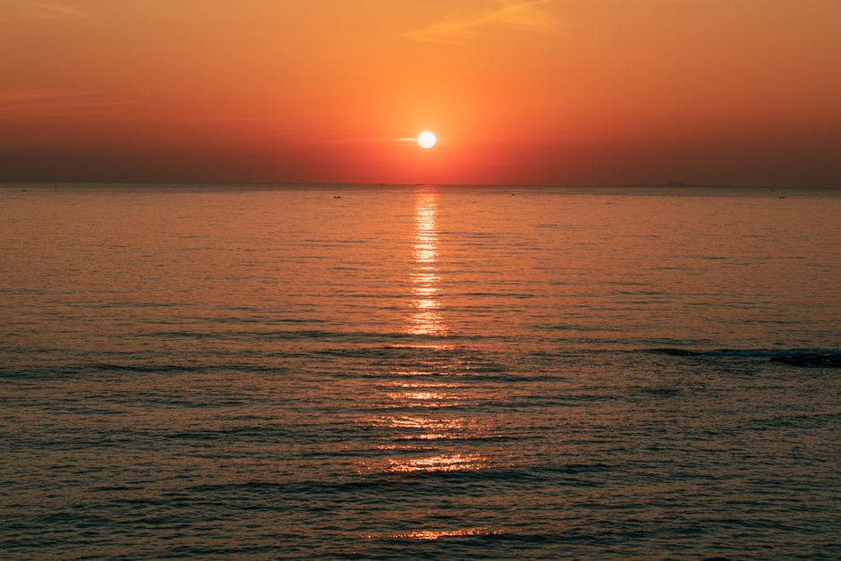 Breathtaking view of sunset reflecting on the tranquil water at Cua Tung, Vietnam.