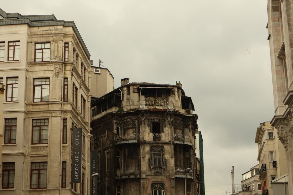 Contrast of historic decay and modern architecture in urban street scene.
