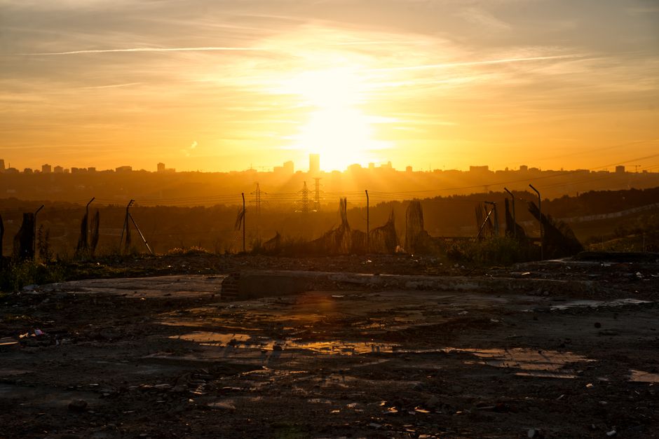 Dramatic sunrise illuminating a city skyline silhouette, ideal for urban landscape themes.