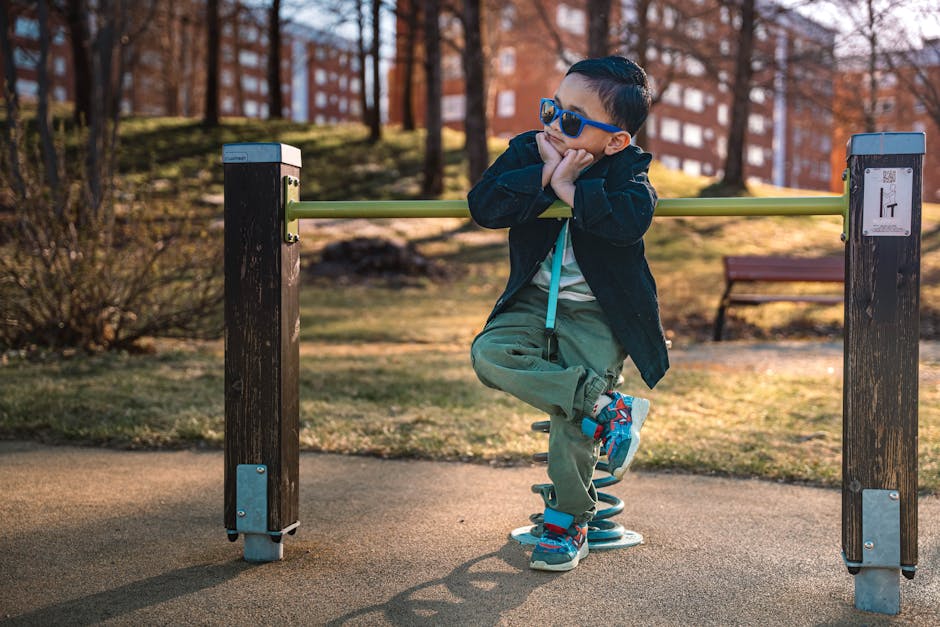 Young boy in stylish attire posing on playground in Sweden during daytime.