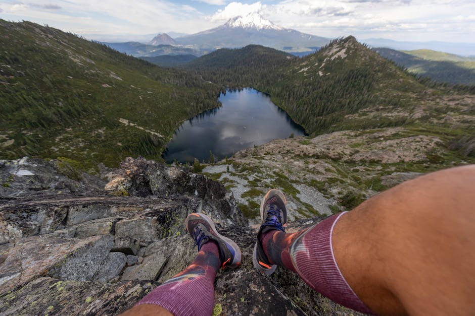 A hiker enjoys a stunning mountain landscape with a serene lake view, perfect for adventurers.