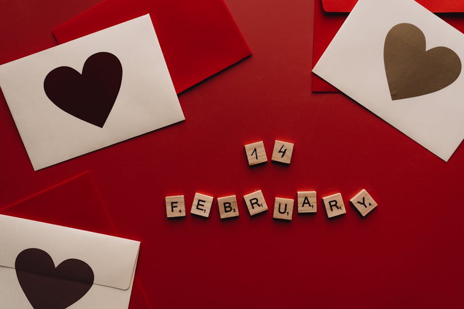 Heart-themed Valentine's Day cards and Scrabble tiles spelling February 14 on a red background.