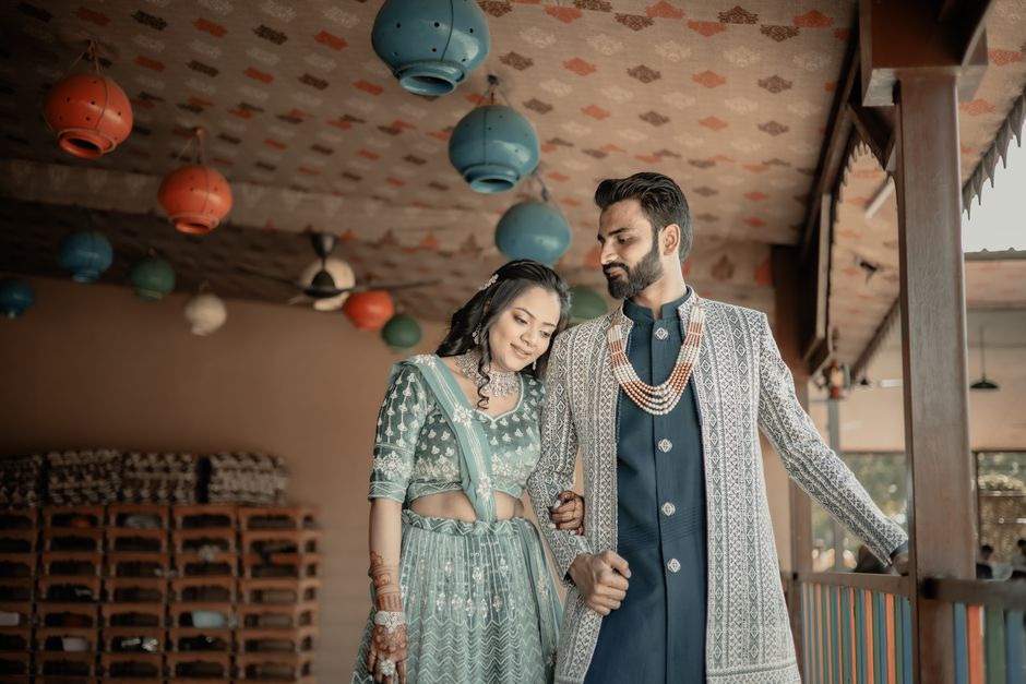A couple in traditional attire posing indoors for a wedding photoshoot.