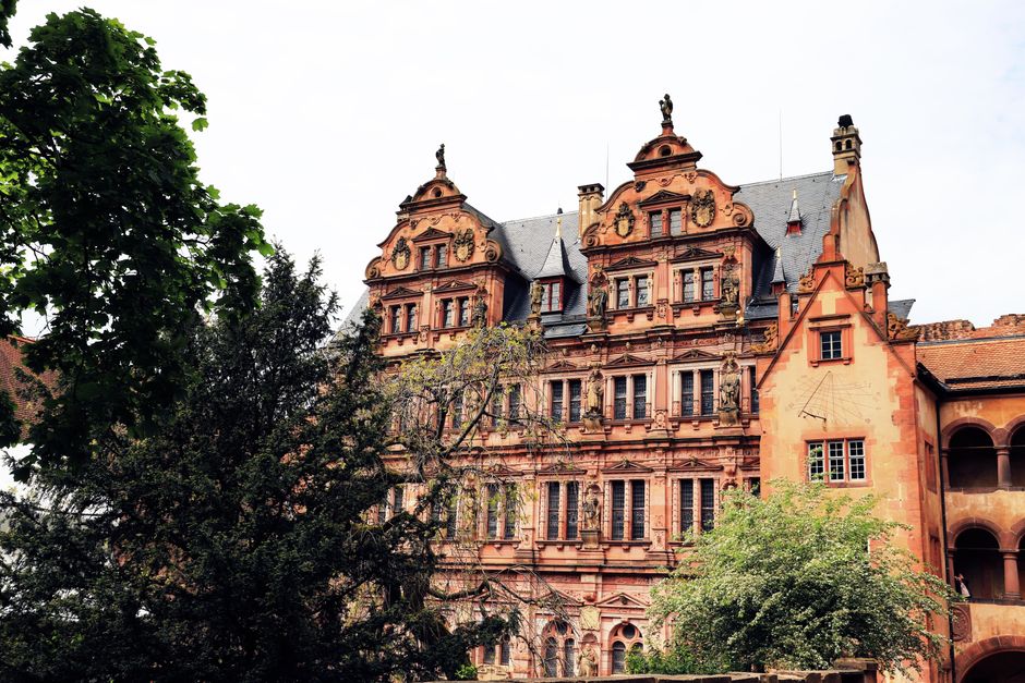 Beautiful Renaissance facade of Heidelberg Castle surrounded by lush trees in spring.