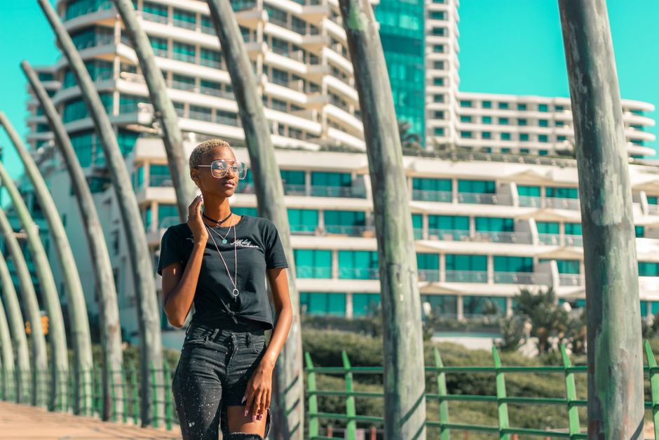 Confident woman in casual attire walking along Durban's iconic beachfront promenade.